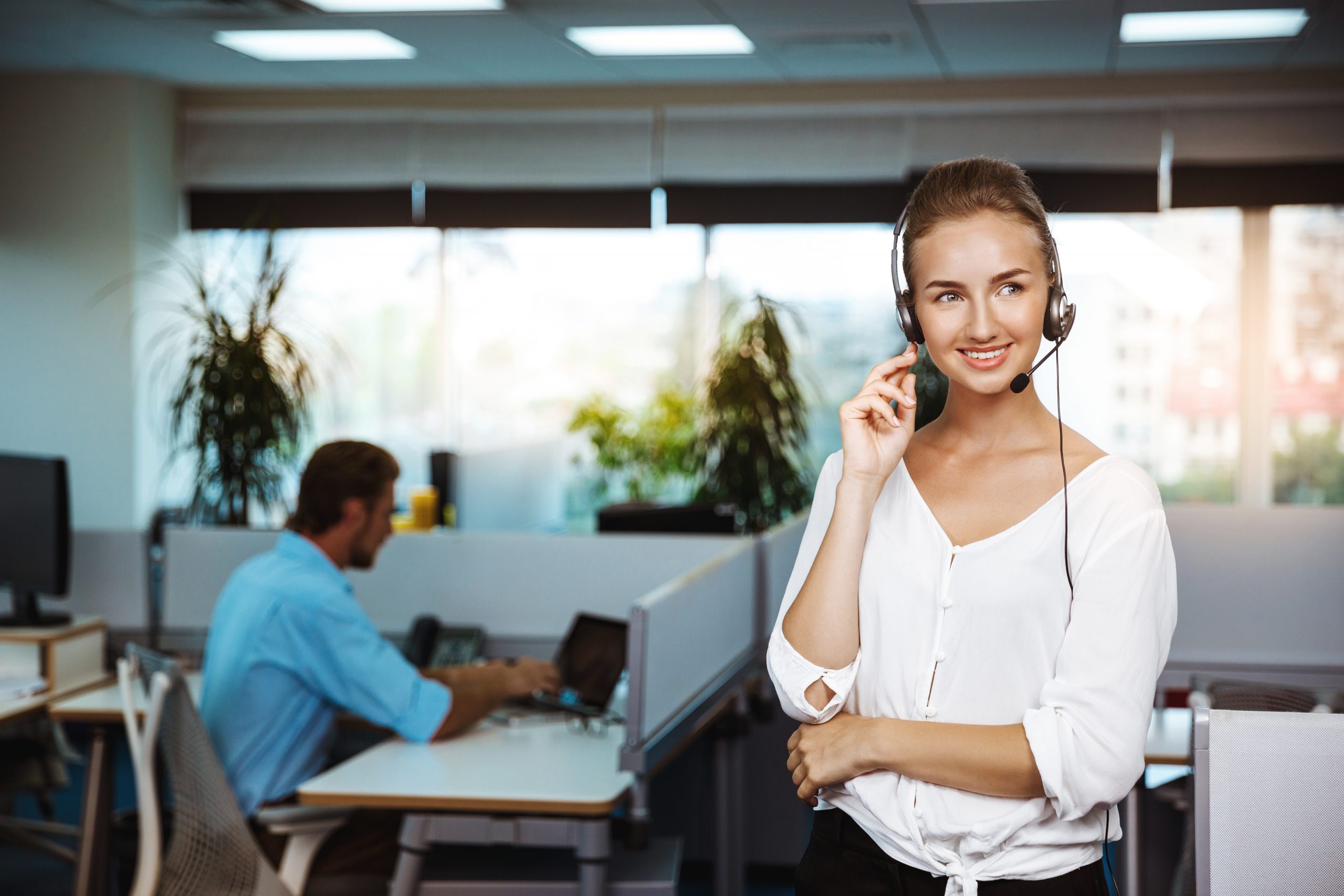Young beautiful female support phone operator speaking, consulting, over office background.